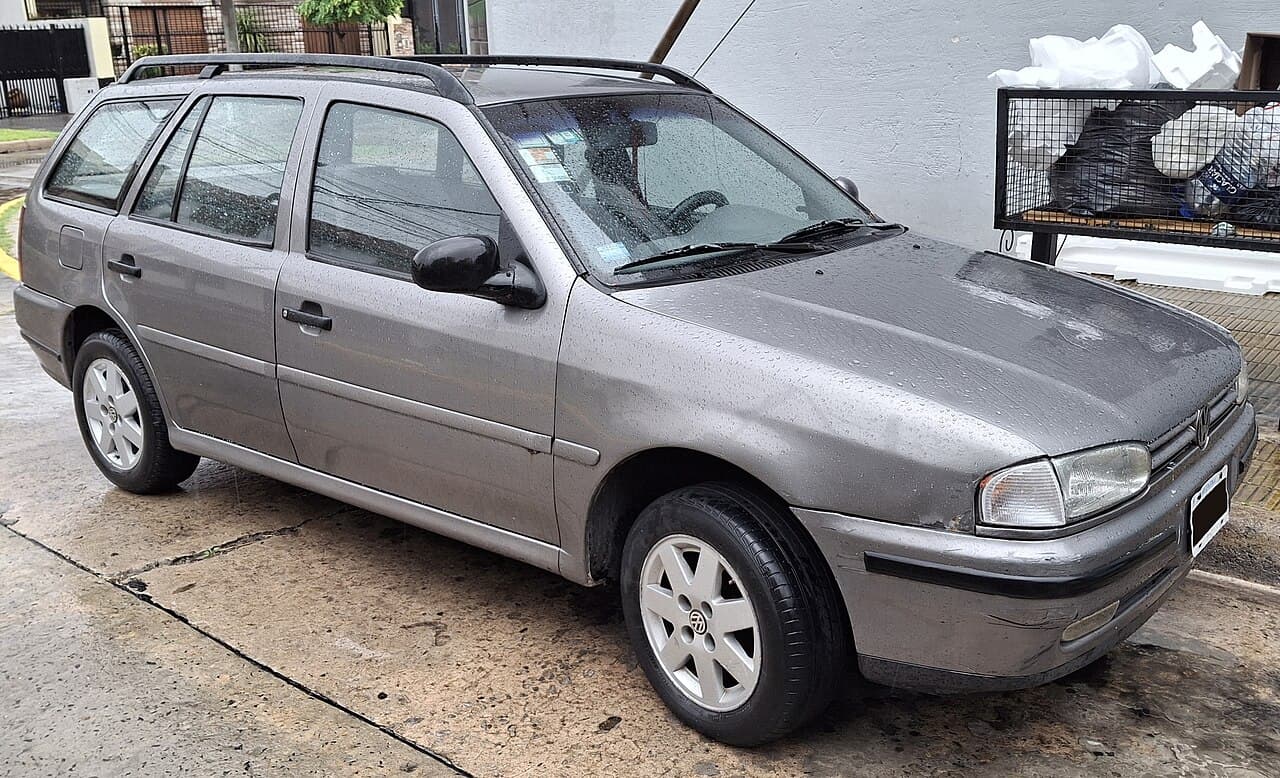 Volkswagen Gol Country gris, rural de cinco puertas con barras de techo, visto desde adelante y de costado en una calle de Buenos Aires.