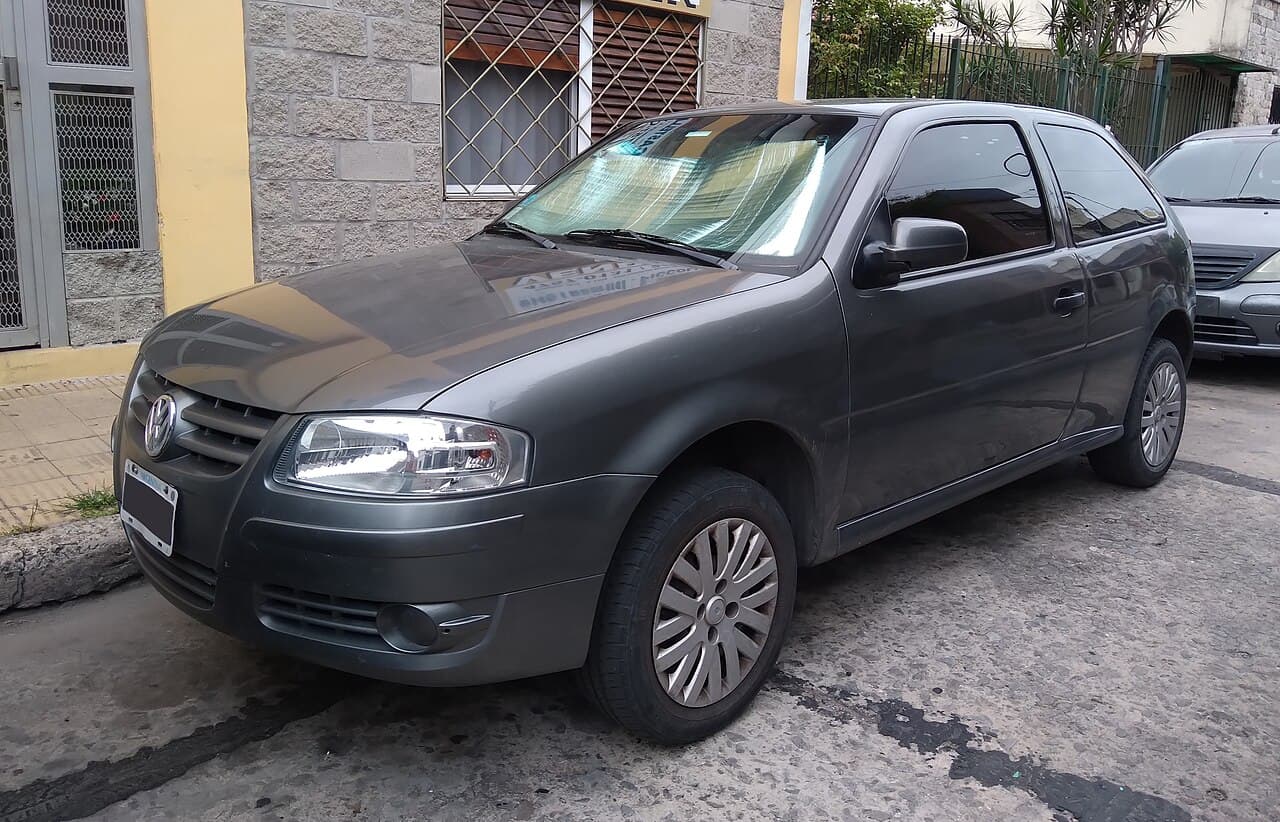 Volkswagen Gol Power gris de tres puertas, de la generación G4, visto desde adelante y de costado en una calle.
