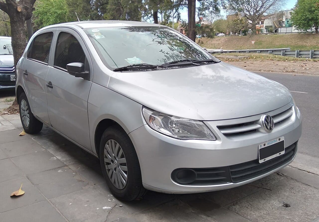 Volkswagen Gol Trend plateado de cinco puertas, visto desde adelante y de costado, con tapas de rueda y patente argentina.